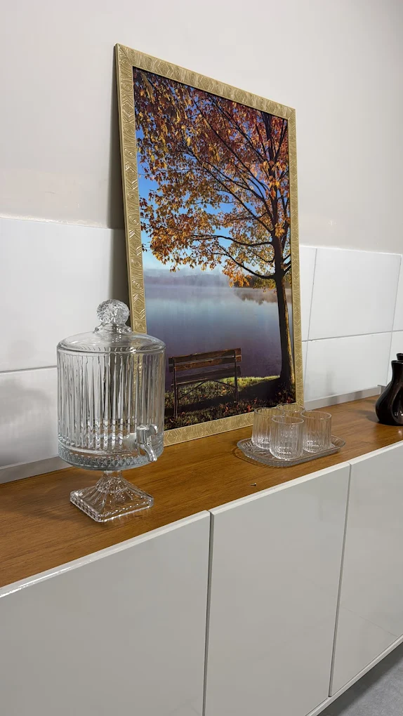 Detalhe do balcão com bomboniere de cristal e quadro de árvore outonal